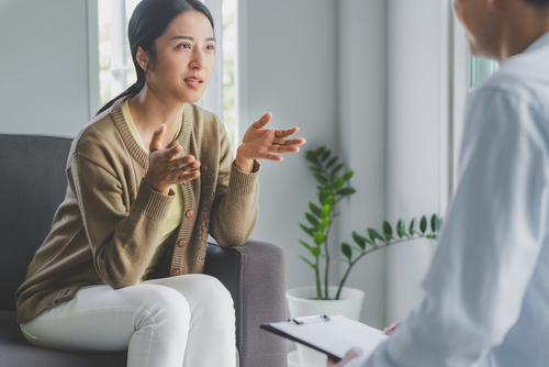 Woman in brown speaking with her doctor about mental health