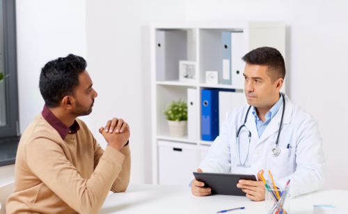 A patient and doctor sitting at a table discussing testicular cancer