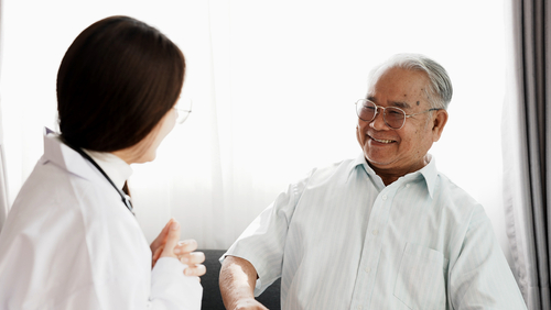 Geriatrician speaking to an elderly patient about medical treatment