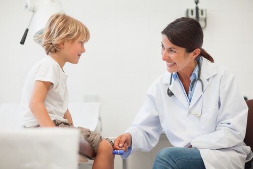 Pediatrician examining a child for juvenile arthritis symptoms