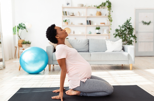 Pregnant woman practicing pain management by doing yoga