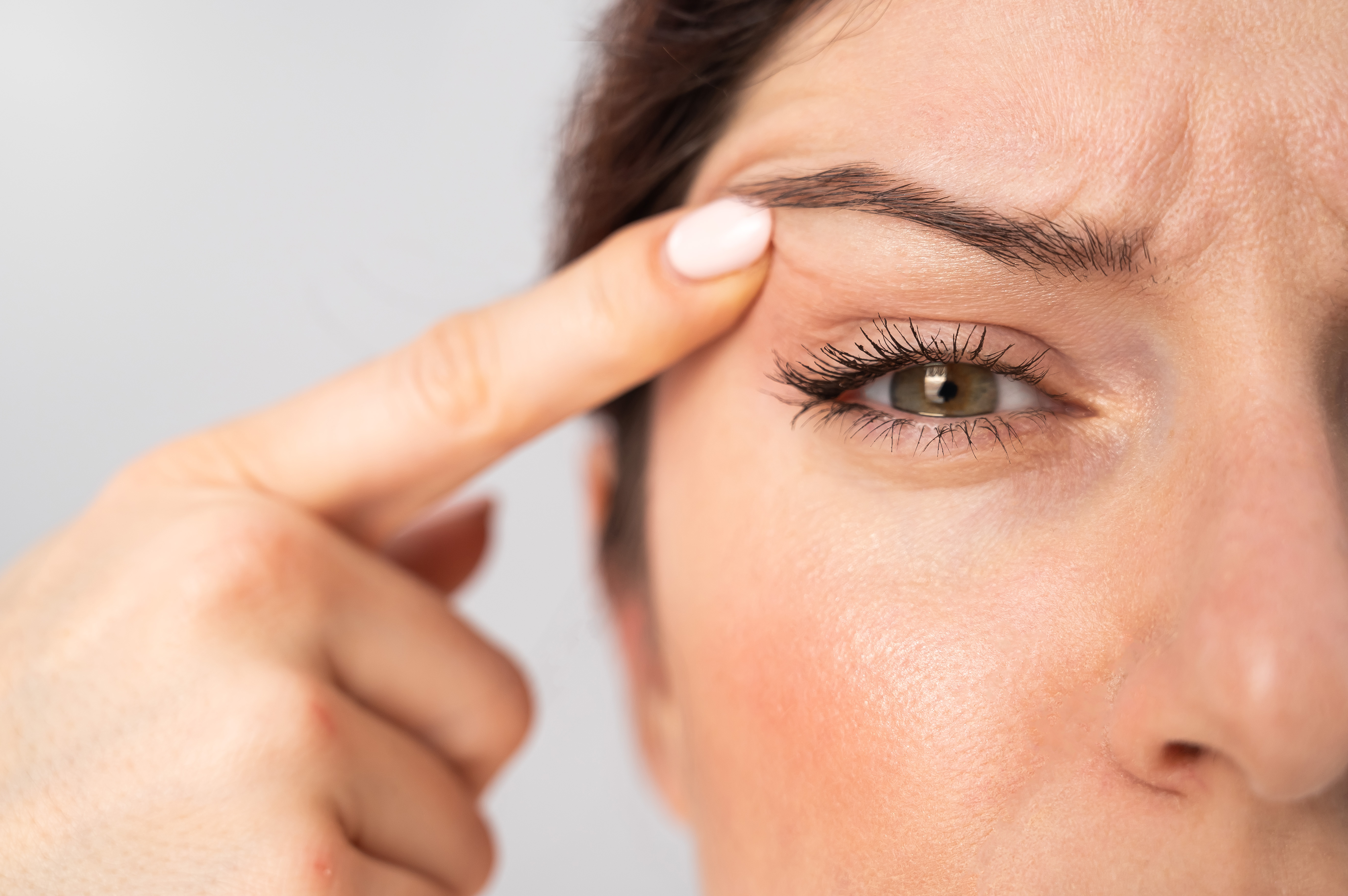 Woman examining face due to eyelid twitching