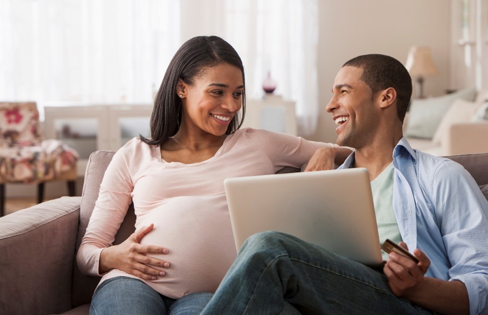 Pregnant woman smiling at her partner on the couch