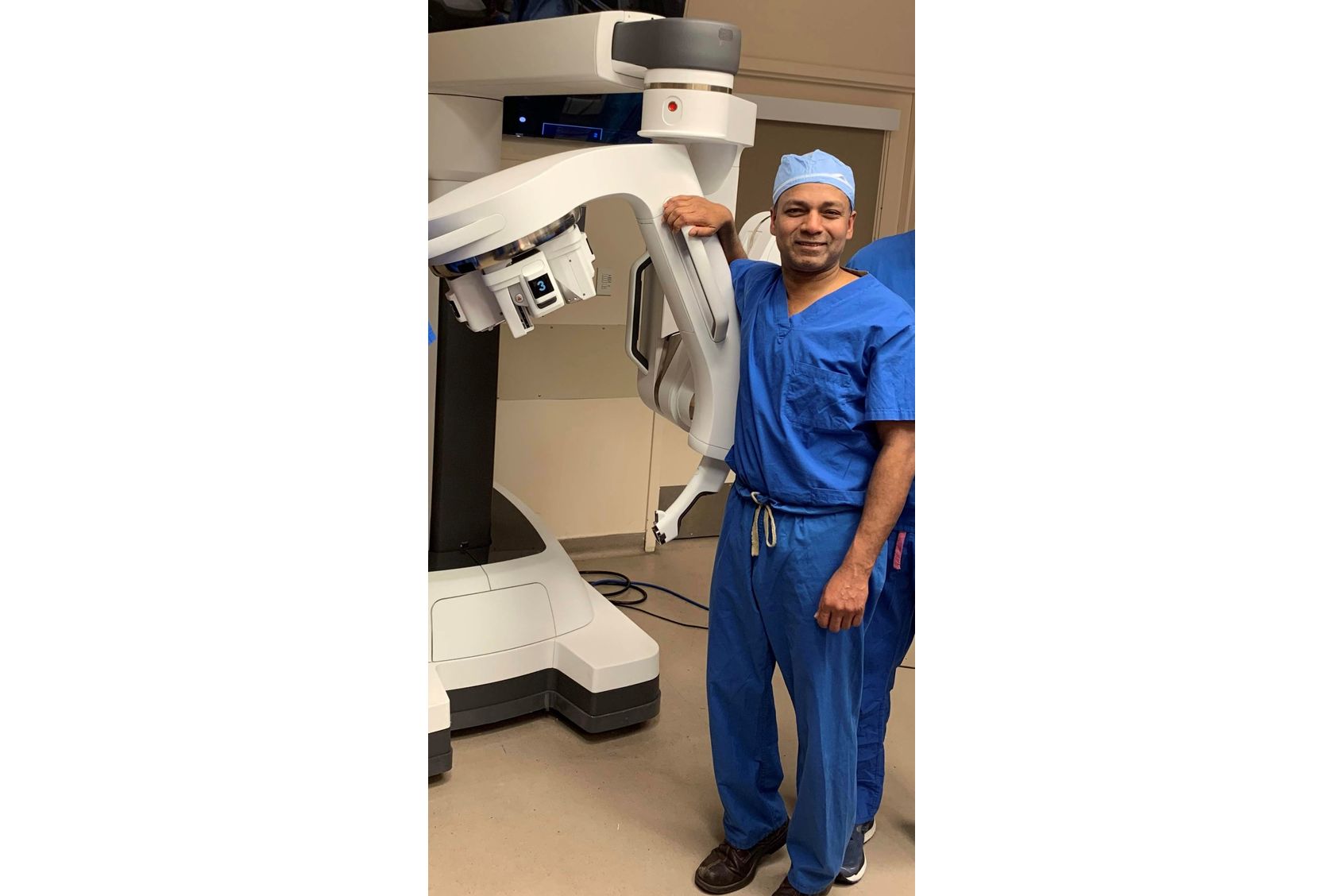 Urology provider standing next to robotic surgery machine
