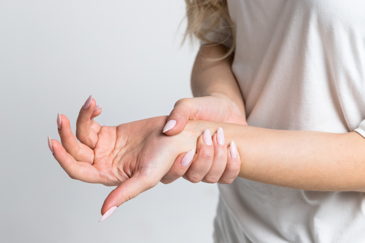 Woman grasping her wrist after experiencing carpal tunnel syndrome symptoms