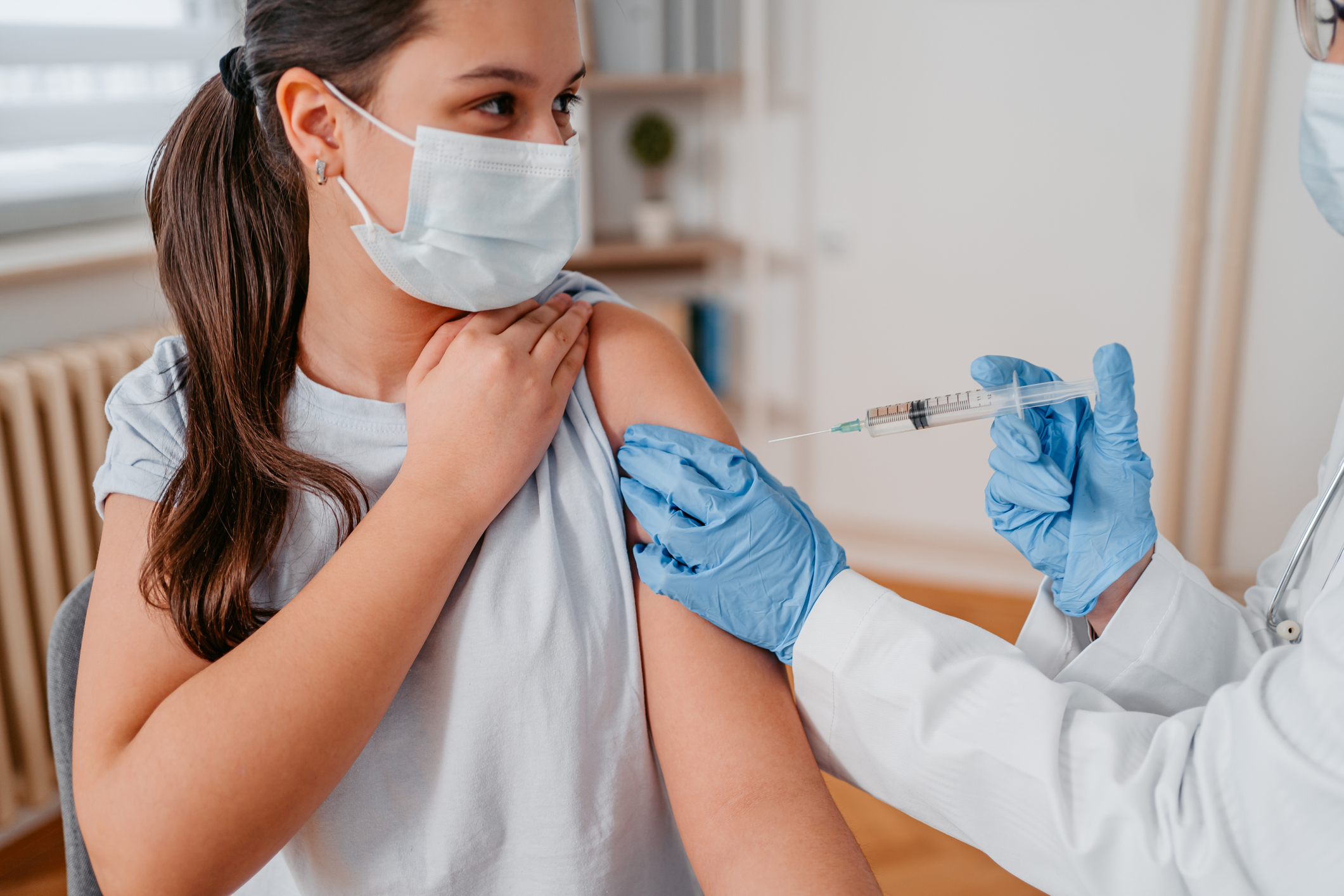 Woman in facemask receiving the HPV vaccine