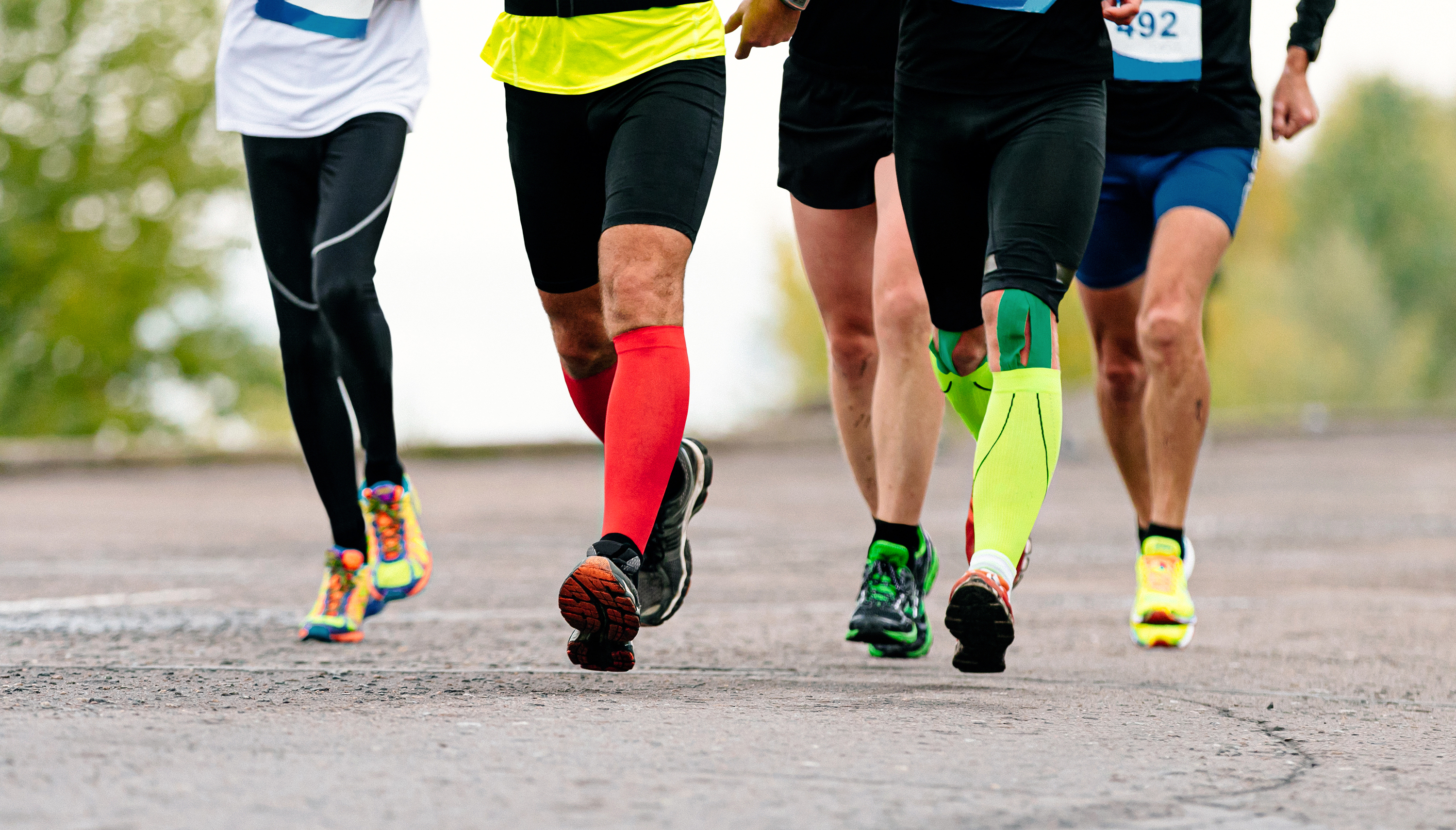 Joggers using colorful compression socks to help with blood flow