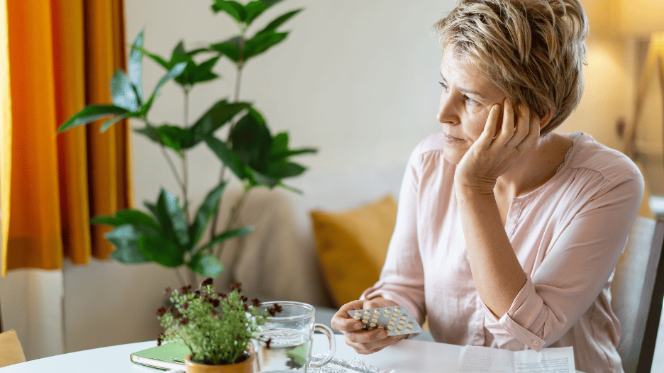 Woman with low estrogen symptoms sitting at a table