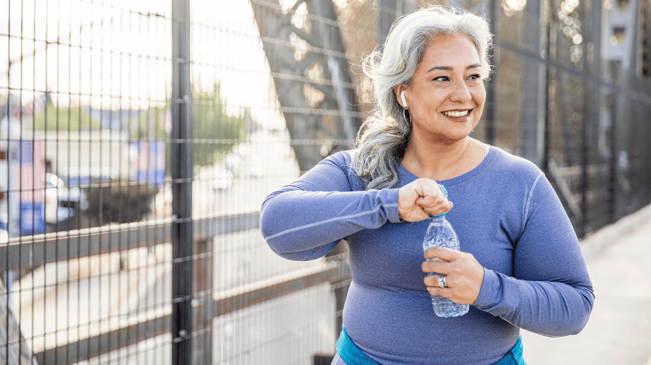 Active woman drinking water from a bottle during a workout for proper sports hydration