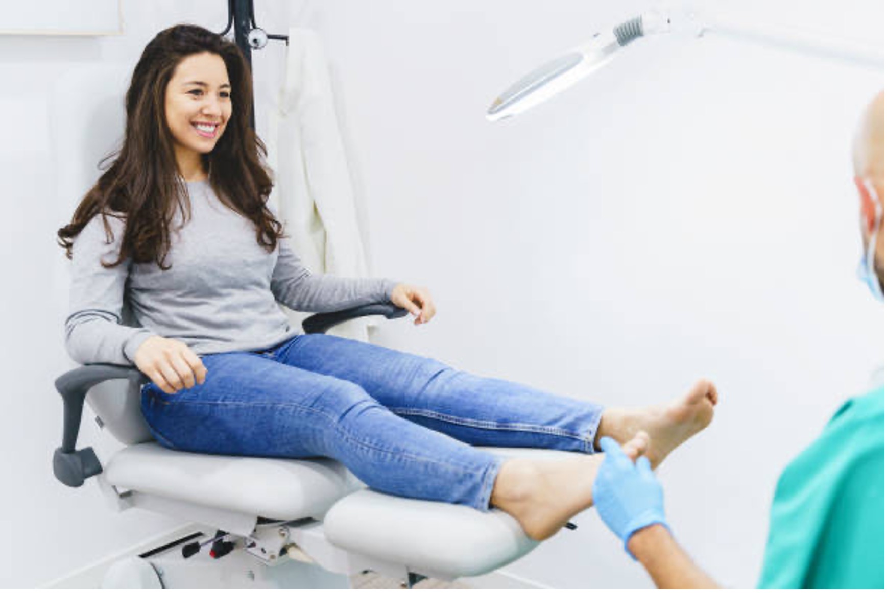 Horizontal side view of brunette woman sitting on doctor's chair having a specialist appointment at medical clinic. Healthcare and medicine lifestyle.