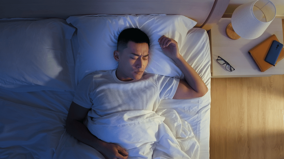 A man sweating while sleeping in bed