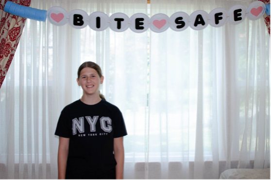 teenager standing under bite safe banner
