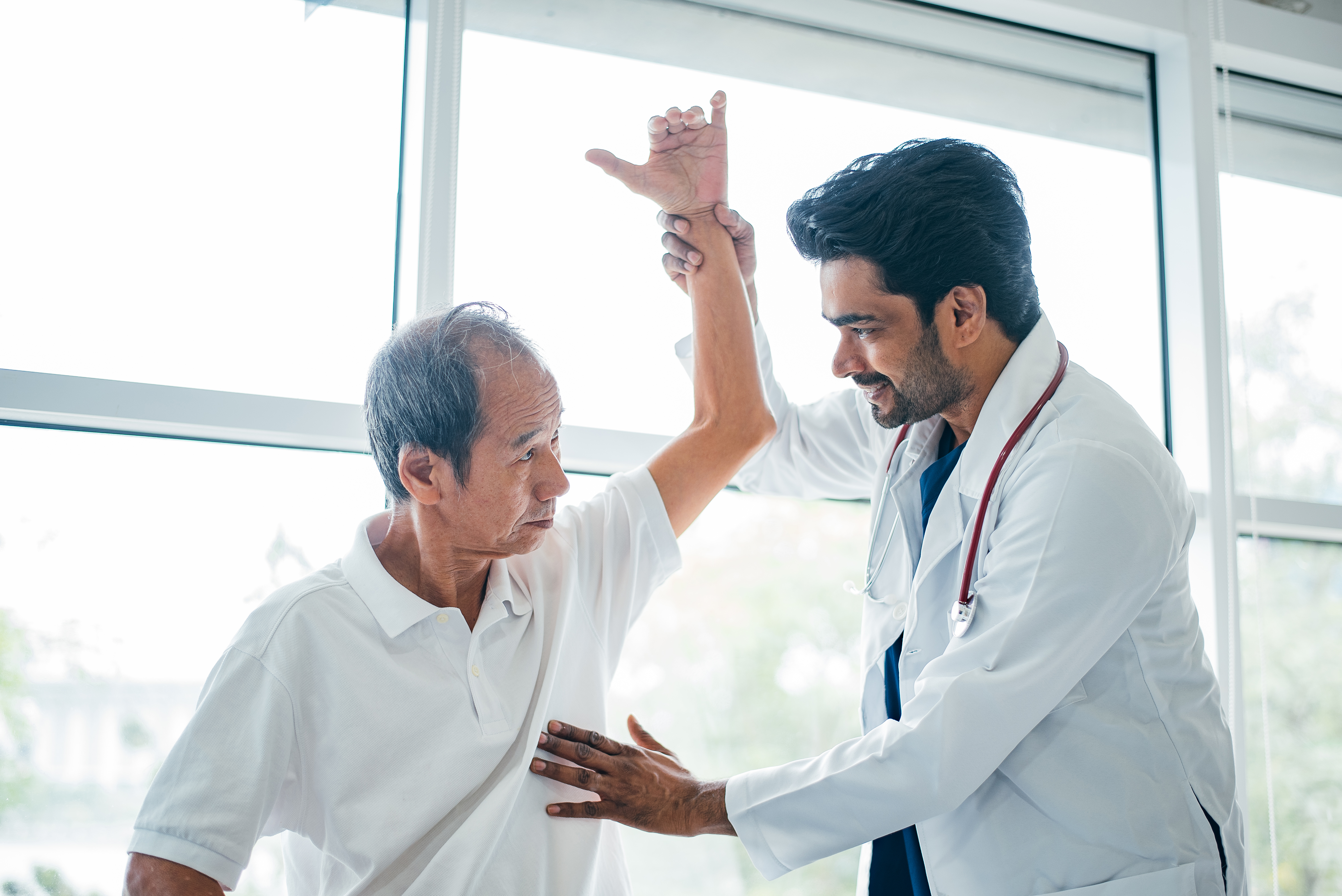 A primary care physician examines an older male patient during a medical appointment