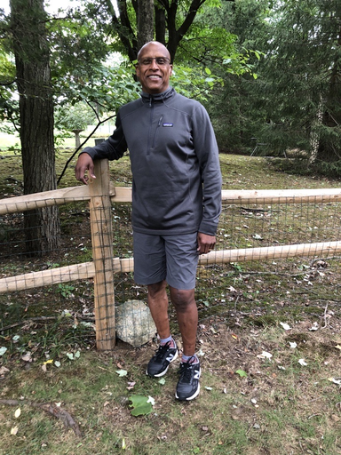 Summit Health patient posing by the fence after successful knee replacement surgery