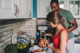 Man and woman making food in the kitchen to help with metabolic syndrome