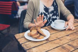 Woman with celiac disease refusing a plate of bread at a restaurant