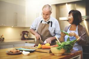 Man and woman preparing vegetables for a meal to help lower cholesterol