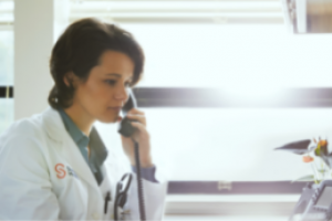 Doctor in a white coat talking on the phone