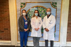 Group shot of Dr. Jennifer Reeder, radiation therapist Nicolette Slattery, and Dr. Peter Hyans in front of a colorful mosaic