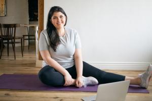 Young woman practicing yoga on a purple mat after bariatric surgery