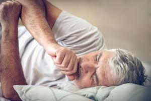 bedridden man coughing and experiencing pneumonia symptoms