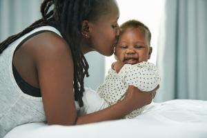 Black woman kissing a baby