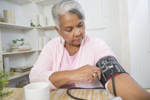Elderly woman taking her own blood pressure
