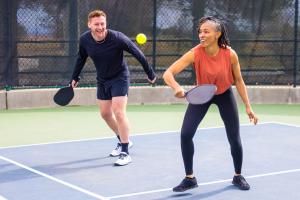 Man and woman playing pickelball