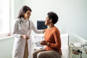 Female doctor talking to a female patient in an examination room