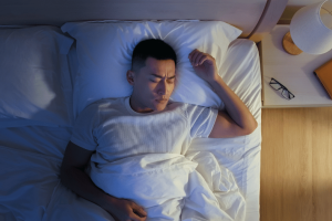 A man sweating while sleeping in bed