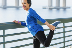 Elderly woman stretching her leg outdoors