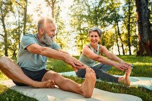 elderly man and woman stretching outdoors