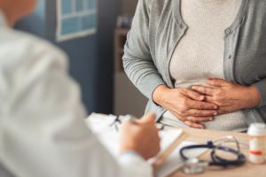 woman holding her stomach with digestive pain
