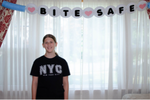 teenager standing under bite safe banner