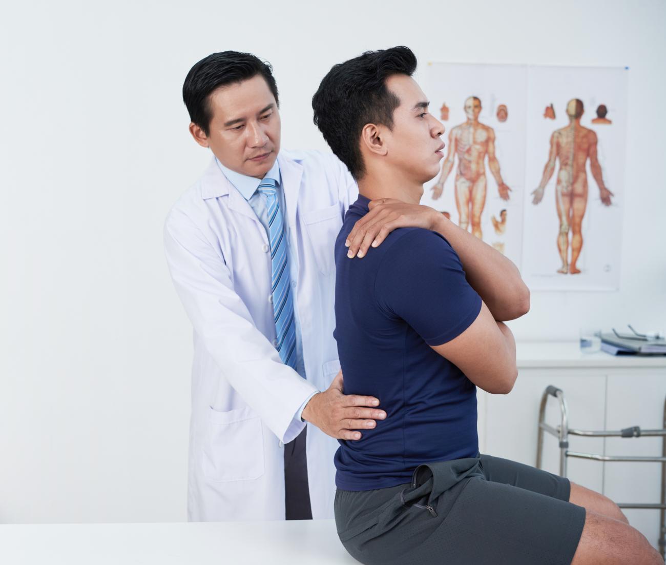 provider adjusting male patient's back in a medical office