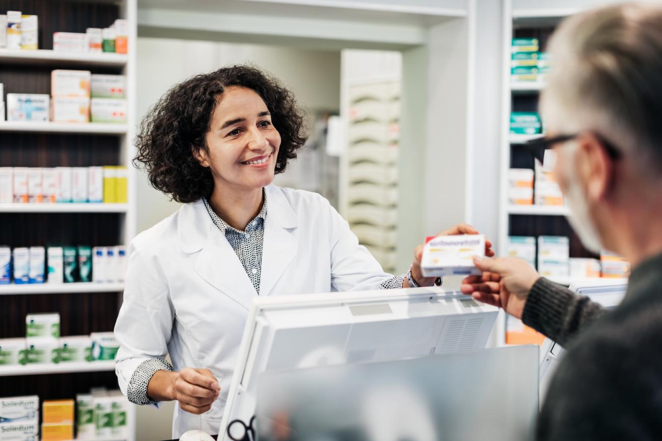 pharmacist handing patient a prescription