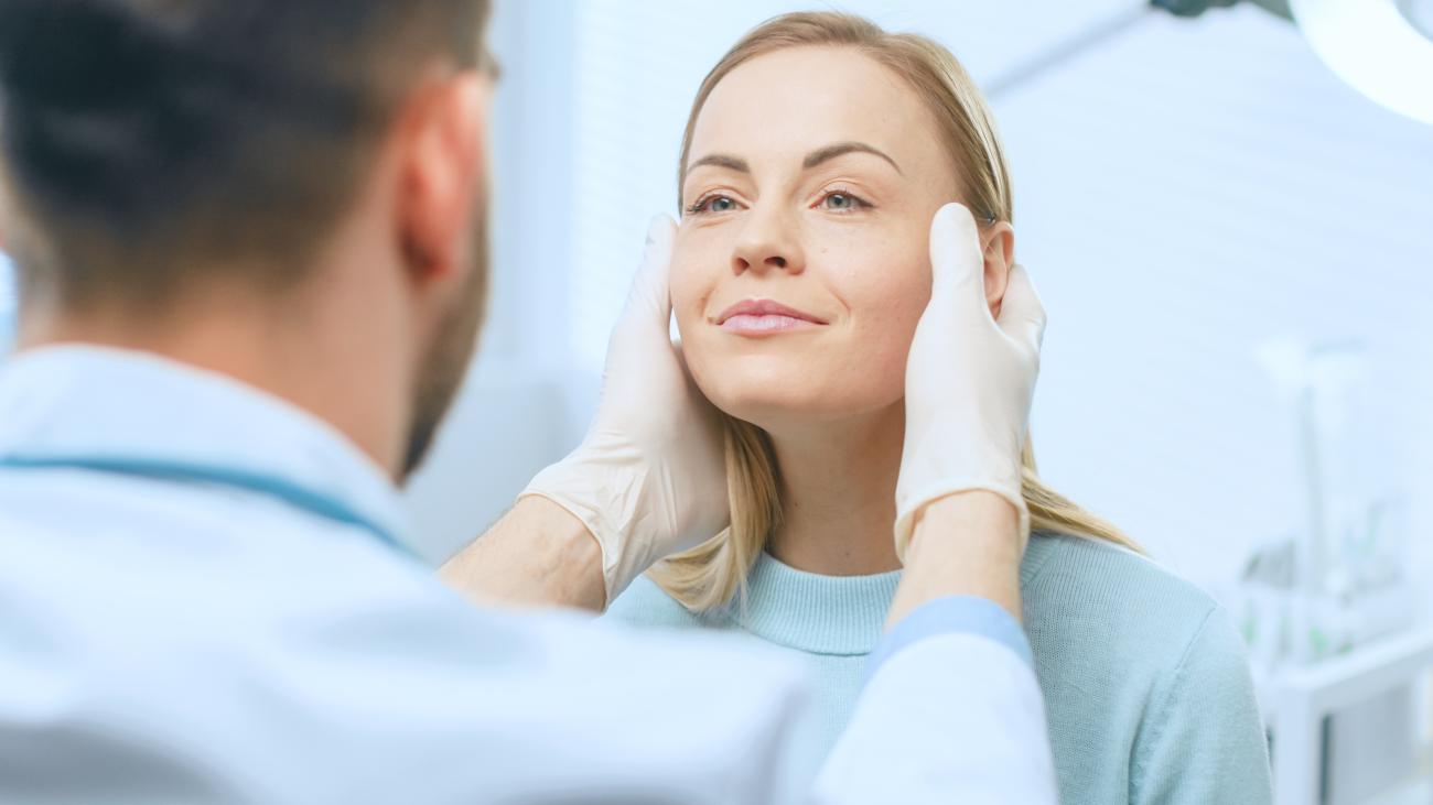 Doctor examining woman's face in a medical office