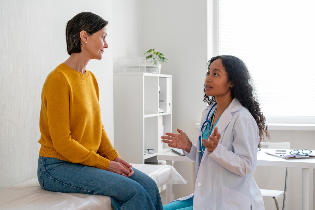 African-American healthcare worker consulting mature female patient in doctor office