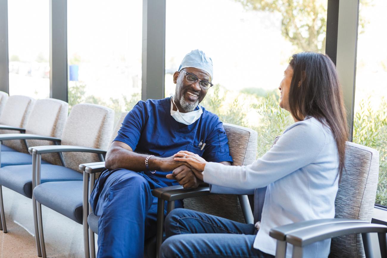  Surgeon smiles as he appreciates the words from his female patient