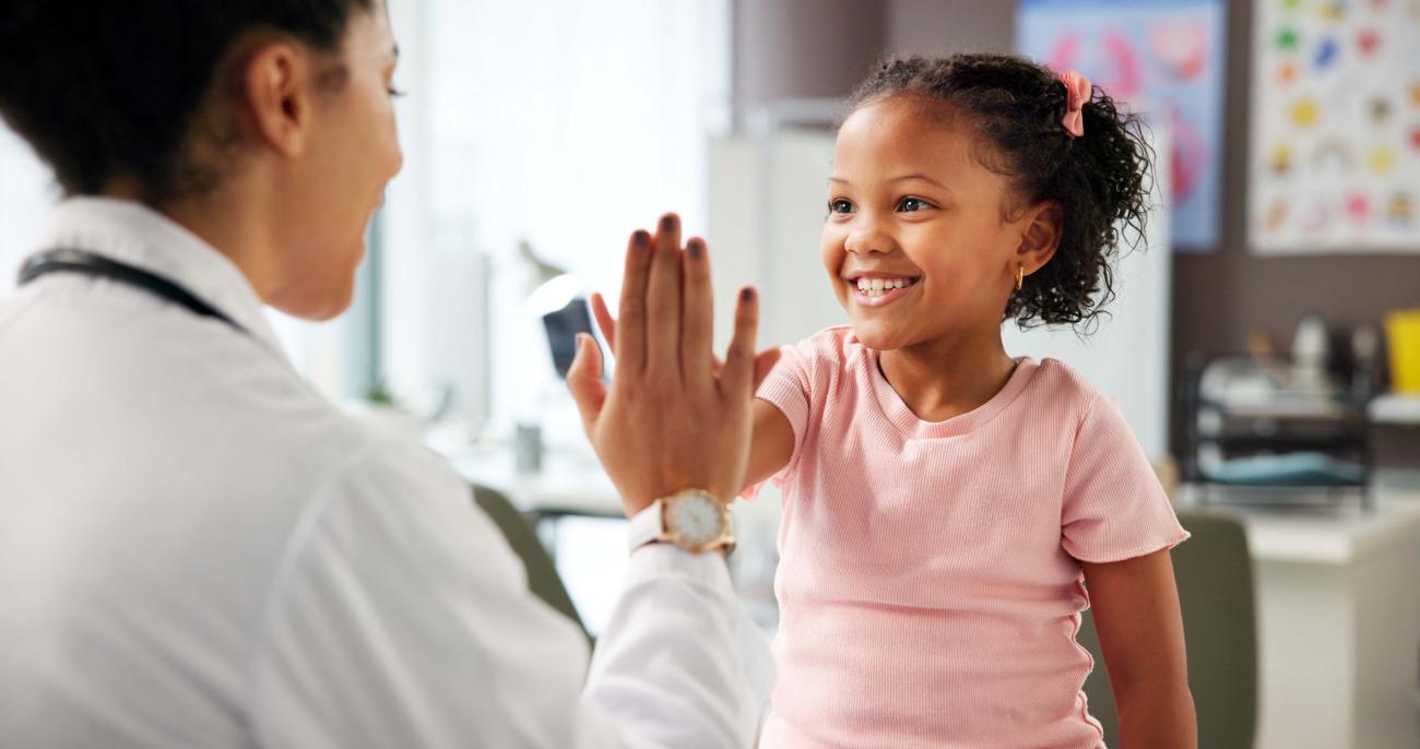 Little girl in doctor's office giving pediatrician a high five