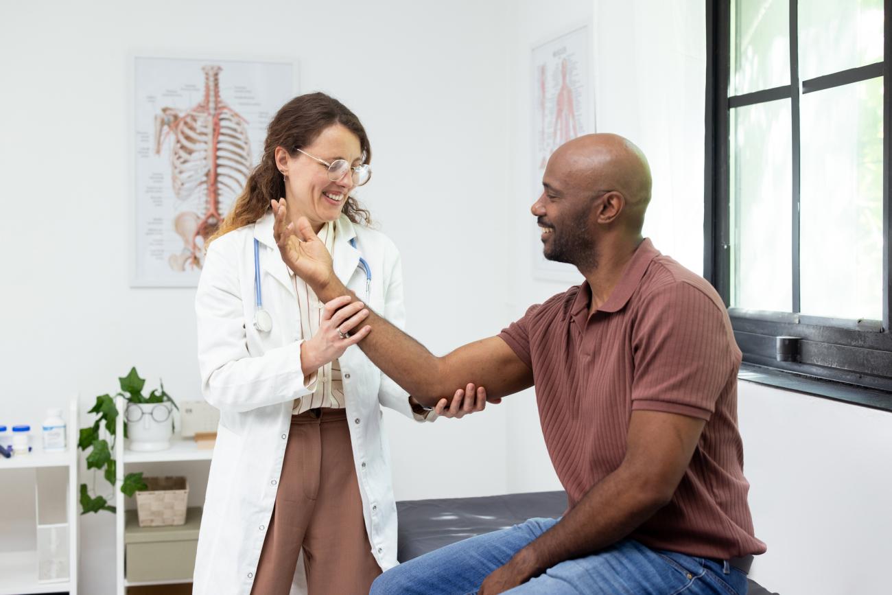 Doctor examining patient's arm during a physical check-up in a clinic