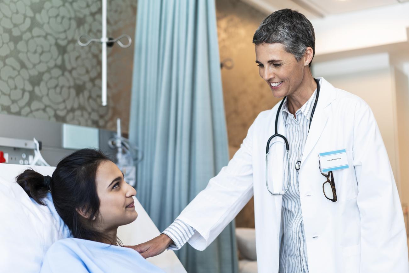  Smiling female doctor comforting patient in hospital