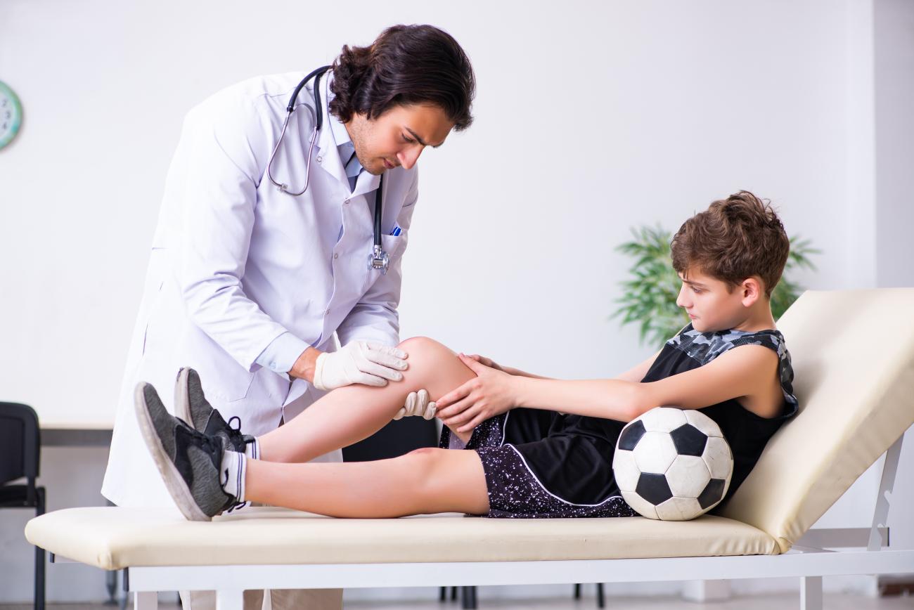 Pediatric orthopedic doctor treating young patient with a sports injury